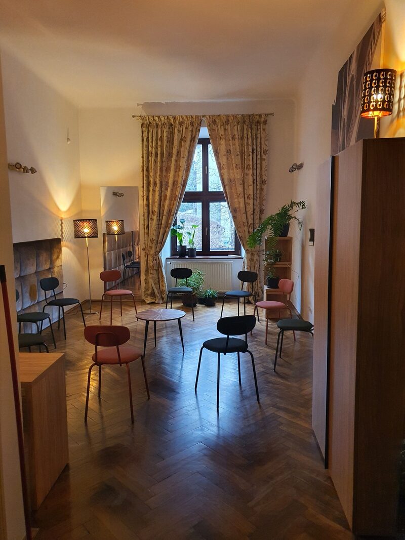 Sala terapii grupowej — krzesła ustawione w kręgu, ciepłe oświetlenie